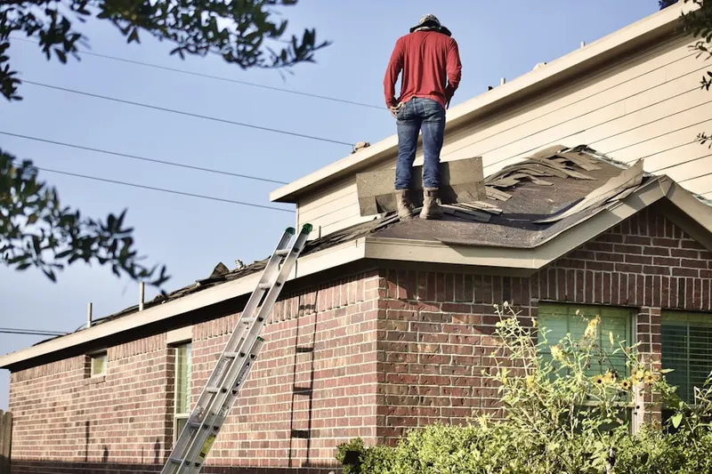 Professional roofer working on a residential roof in Littleton Common